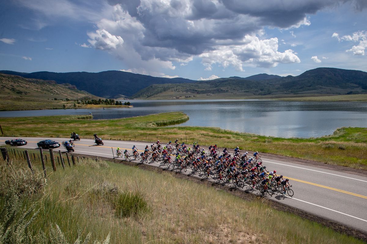 The peloton passes a lake along the course as storm clouds begin to build on stage 1 of the Colorado Classic on August 22, 2019 in Steamboat Springs, Colorado.