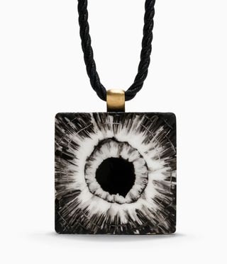 Black necklace with black and white bullet hole on the pendant