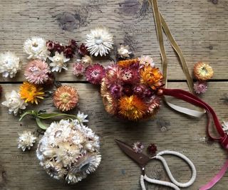 Strawflower baubles and dried heads on wooden table