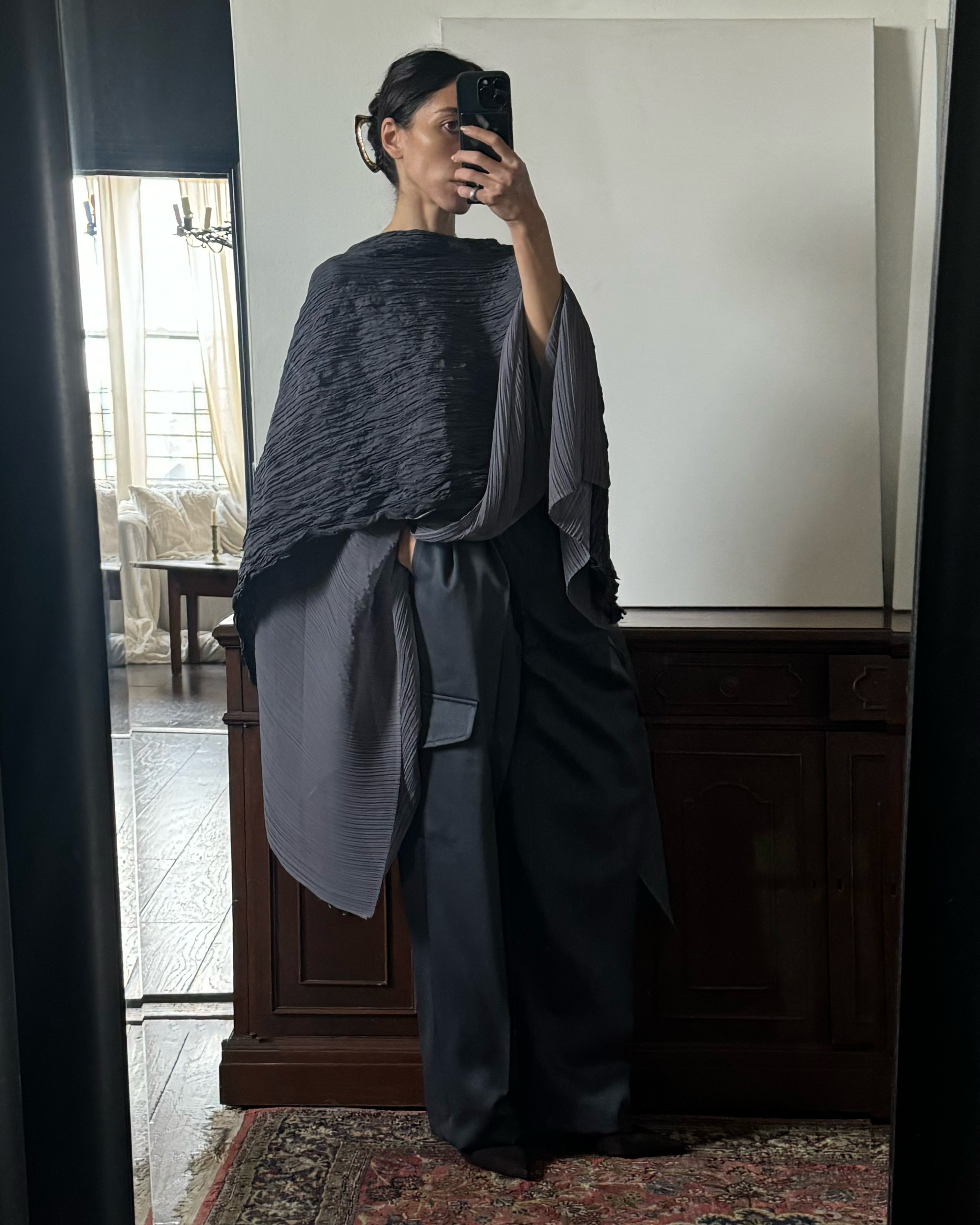 Alexis Badiyi wears a gray shawl over wide leg pants