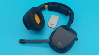 The GHS Wireless InfinitePlay seen from various angles on a blue background. This is a wireless gaming headset from Glorious. It is black all over, save for a few subtle orange accents.