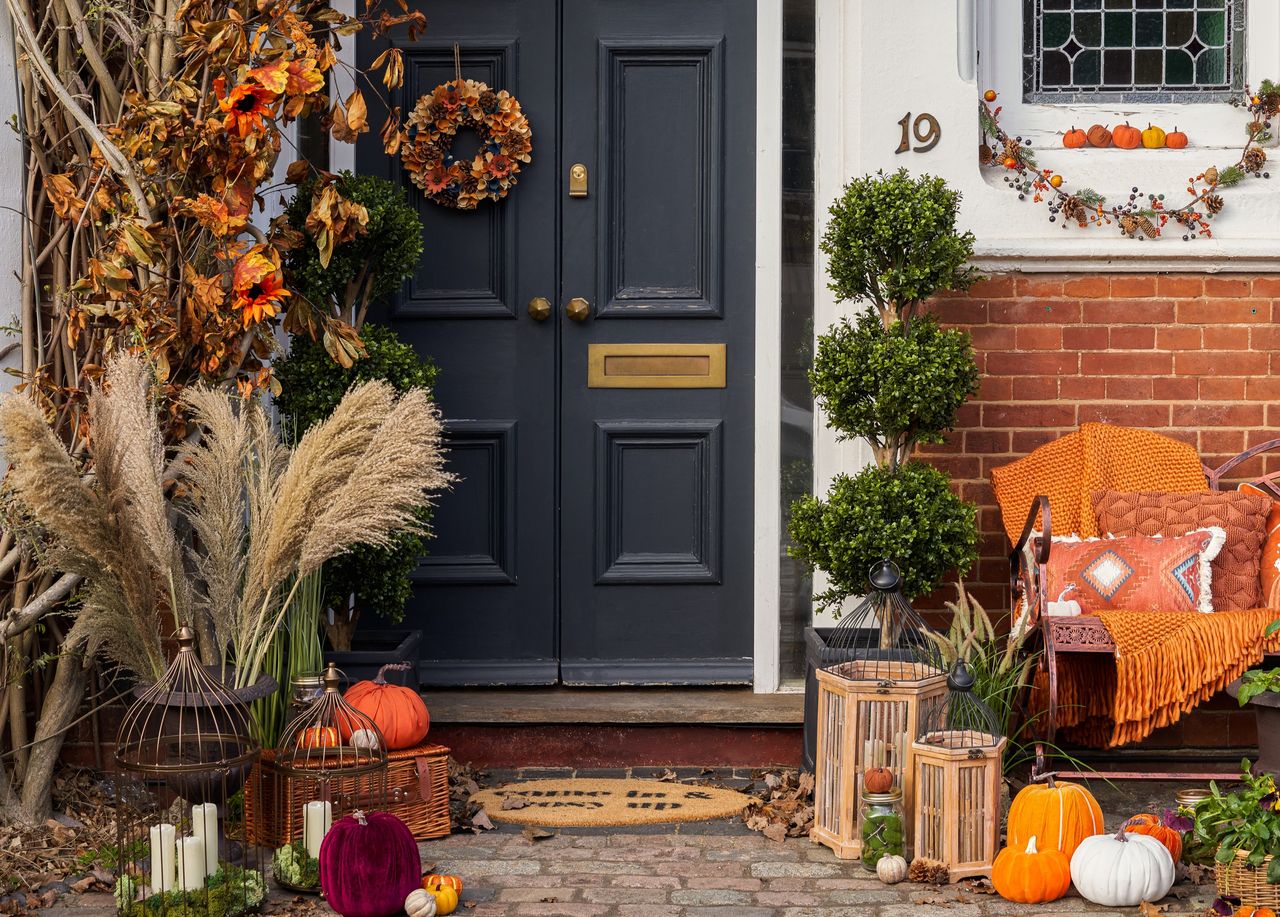 An outdoor space decorated with pumpkins, lanterns, dry flowers and lanterns