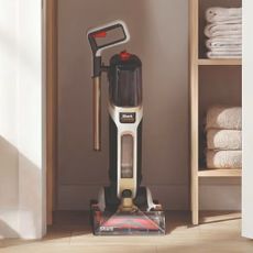 Shark CarpetForce Upright Carpet Cleaner with the wand removed for easy storage in the corner of a room