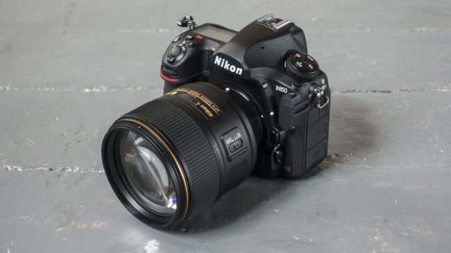 En Nikon D850 ligger på en grå betongyta.