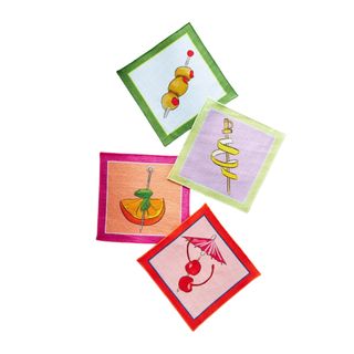 Four square cocktail napkins - one light blue one with an olive illustration, one lilac one with a lemon peel illustration, one orange one with an orange slice illustration, and a pink one with a cherry illustration