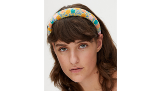 model wearing a yellow floral headband for a christening