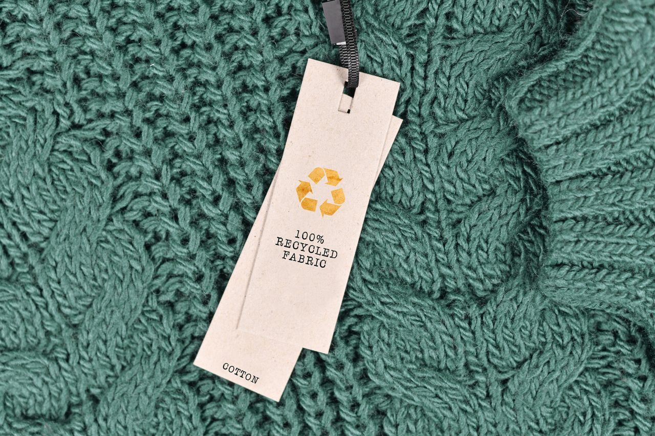 A green jumper with a label saying it&#039;s recyclable 