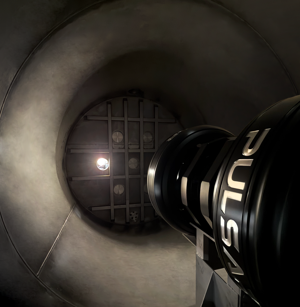 A view from inside a dark cylindrical chamber.