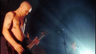 Nick Oliveri playing bass onstage with Josh Homme