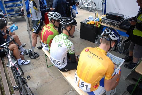 Lars Boom reads the paper with other jersey holders at the start.