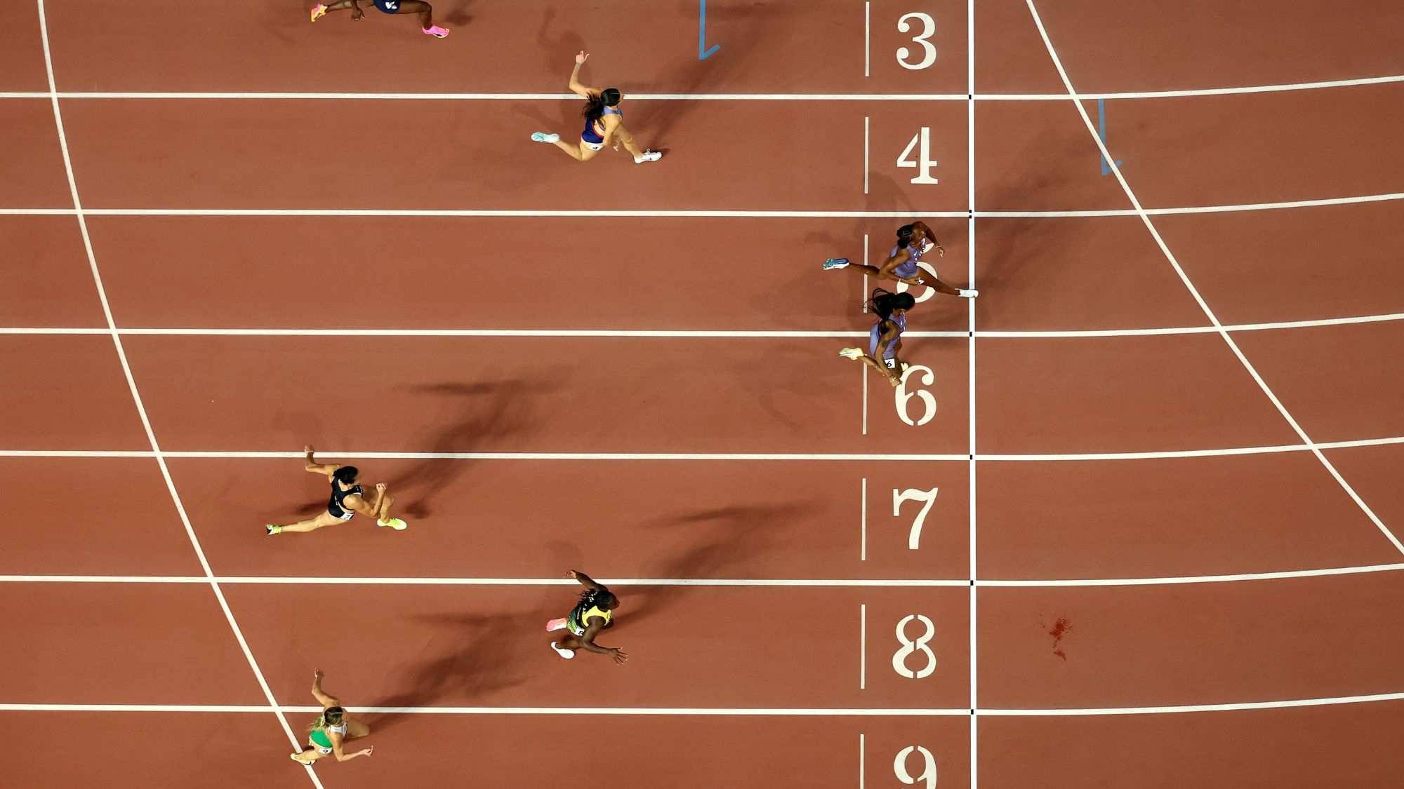 Female athletes crossing the finish line at a track and field event