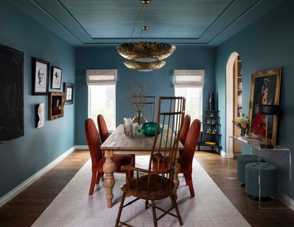 a blue dining room with rust color chairs