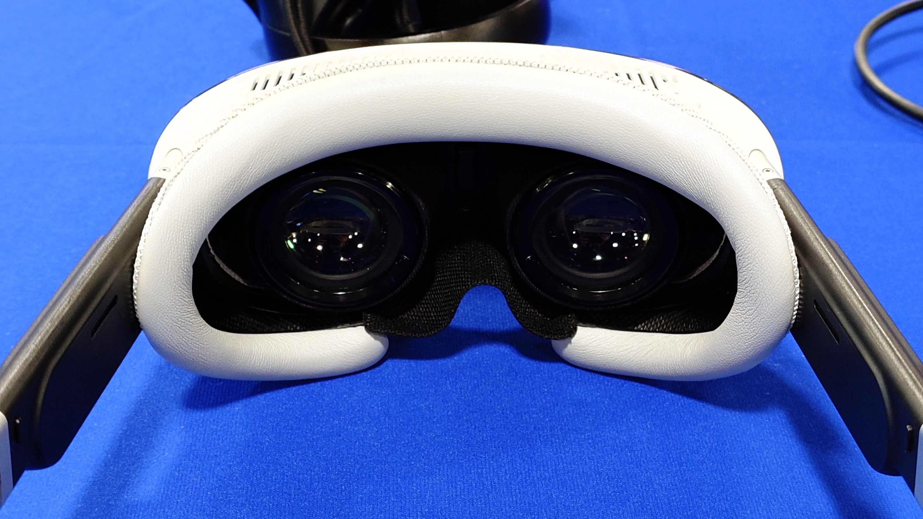 A close up photo of the lenses and padding on the Pimax Dream Air VR headset on a blue table.