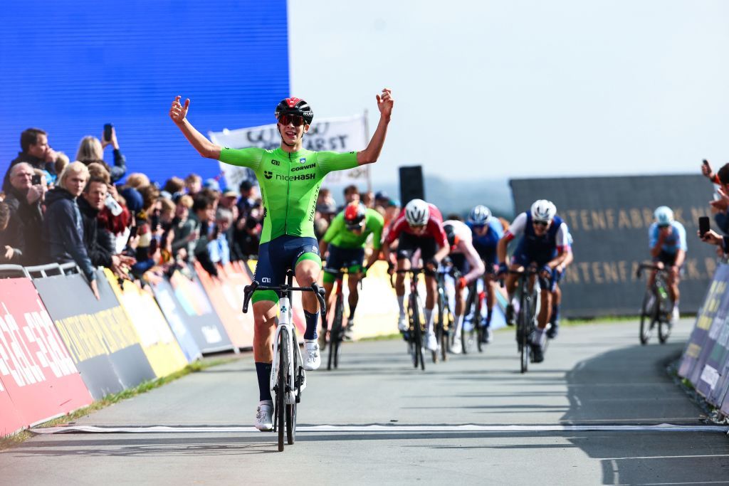 Anze Ravbar celebrates his 2023 junior European road race title victory atop the Col du VAM