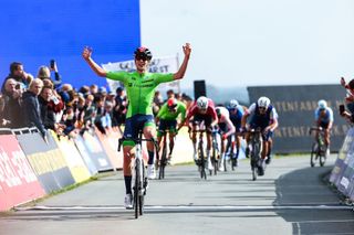 Anze Ravbar celebrates his 2023 junior European road race title victory atop the Col du VAM