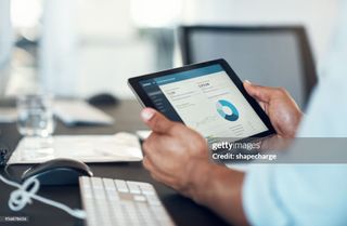 Cropped shot of a businessman using a digital tablet in a modern office