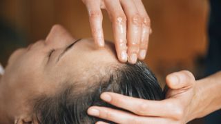 woman enjoying a head massage with essential oils