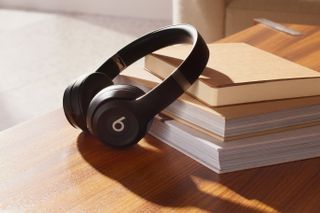 Beats Solo 4 headphones in black resting on some books