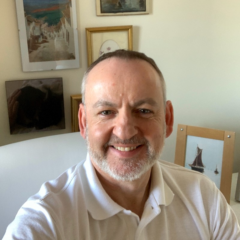 male with short hair, beard wearing white polo shirt