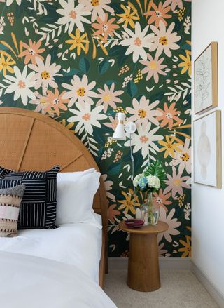 green wallpaper with large white and peach flowers, and wooden rounded bedhead