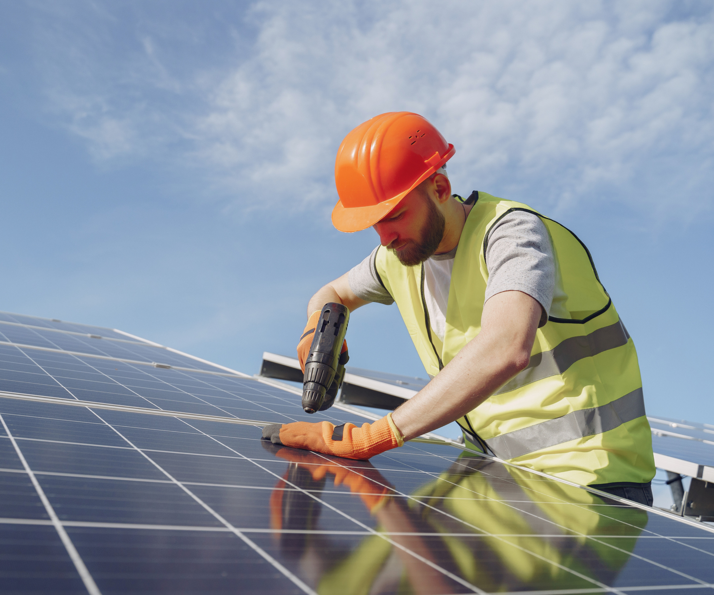 worker wearing PPE installing solar panels
