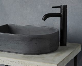 a grey concrete basin in a bathroo