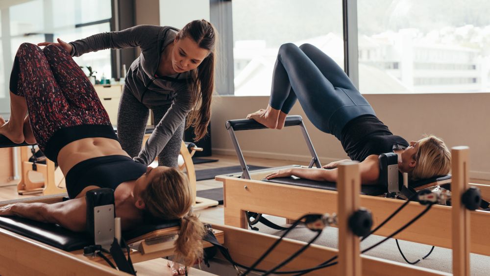 a photo of two women doing reformer pilates 