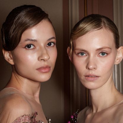 Two models with glowy skin backstage at ziad nakad spring 2025 show