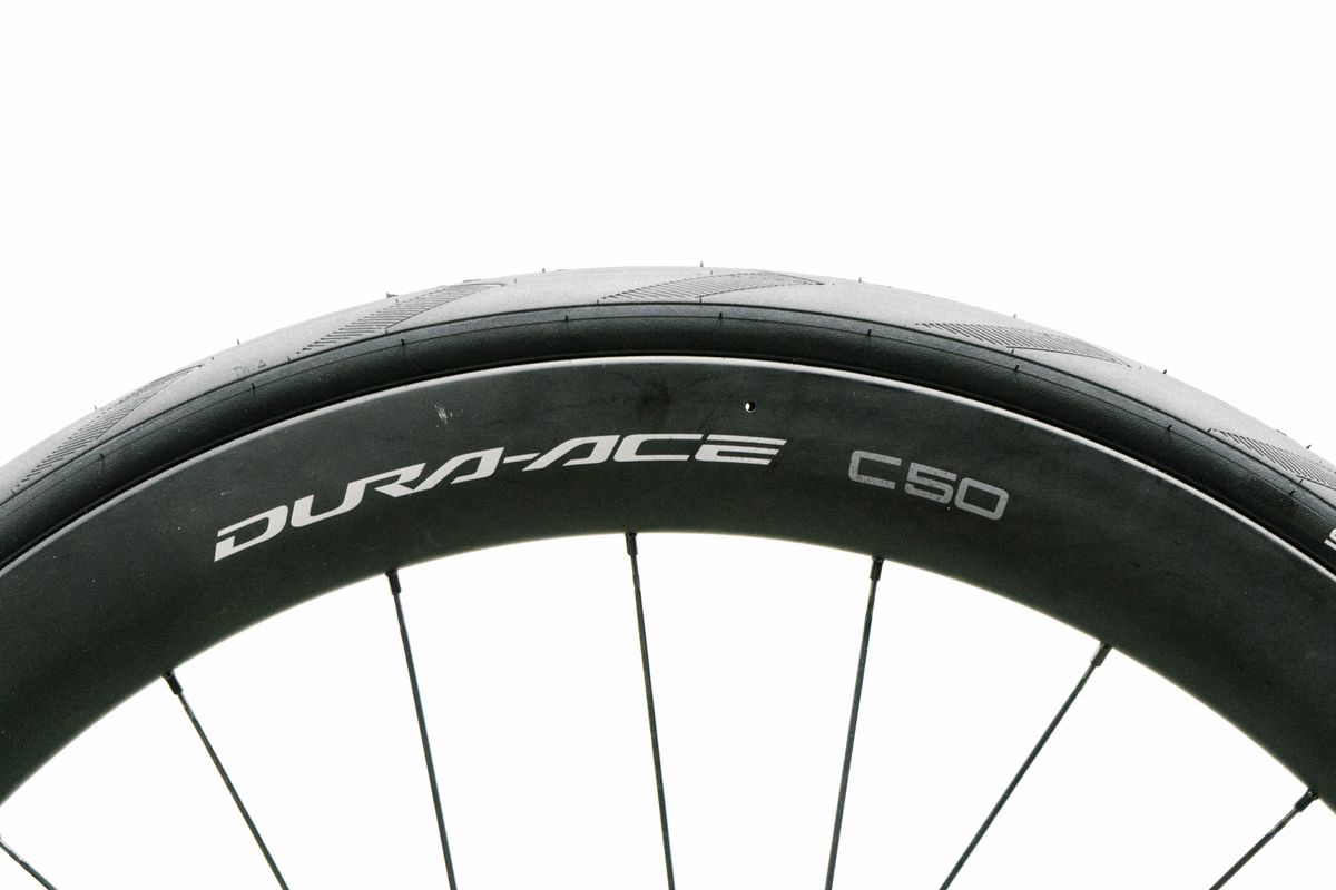 An aero road wheel stands against a white wall