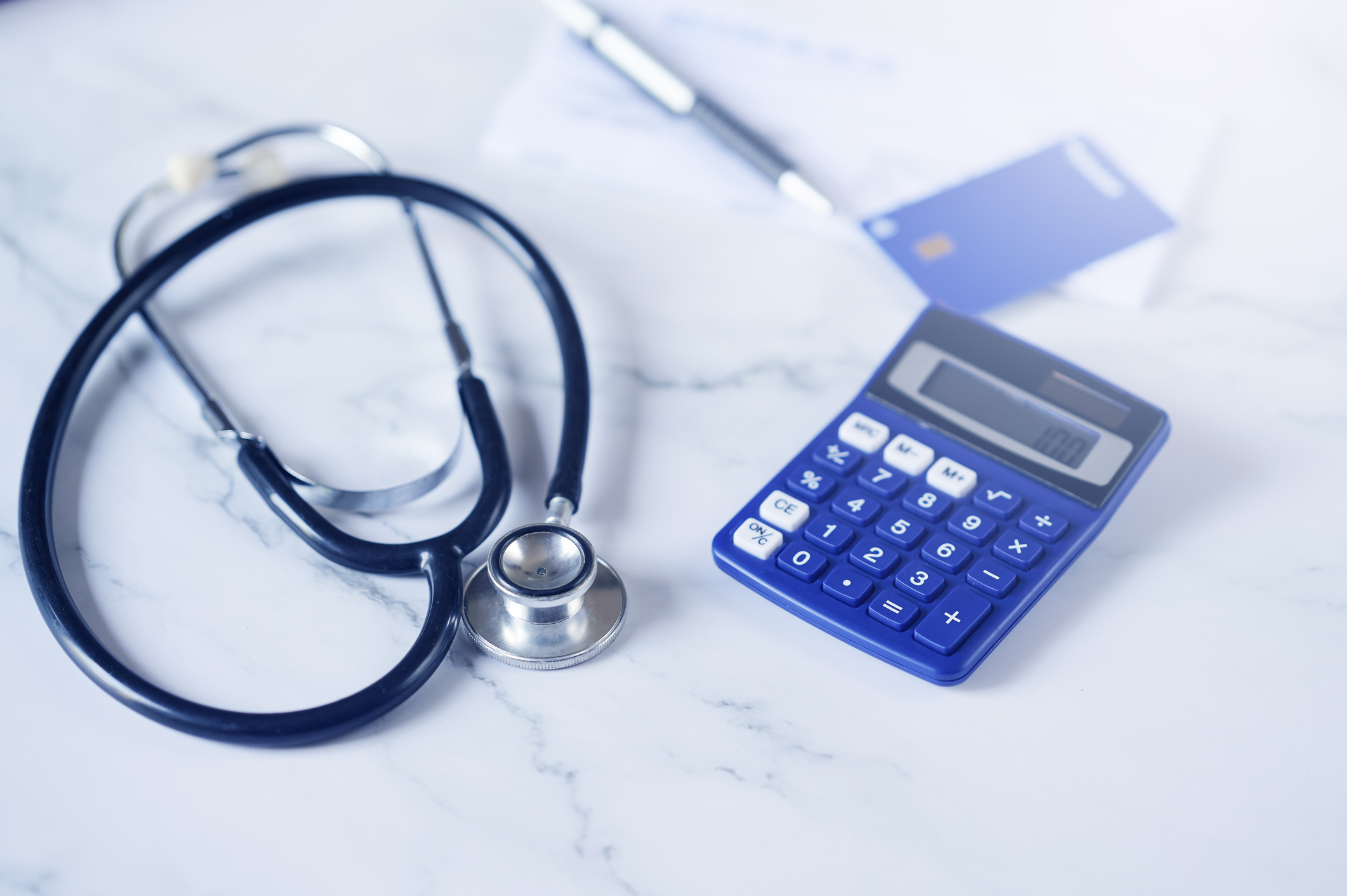 a picture of a stethoscope next to a credit card and calculator