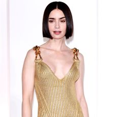 Lily Collins wearing a gold schiaparelli gown