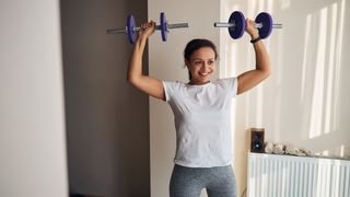Woman performing standing dumbbell shoulder press