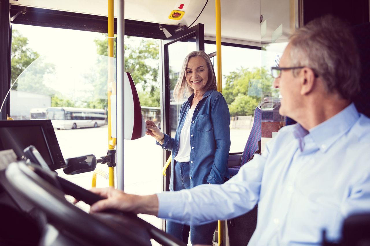 Image of a woman paying on a bus via contactless