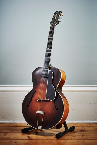 1927 L-5 in ‘Cremona brown’ sunburst. In late 1929, large pearl block inlays replaced the original pearl dot fingerboard markers show here. The headstock features the pre-war ‘The Gibson’ script logo and pearl flowerpot inlay.