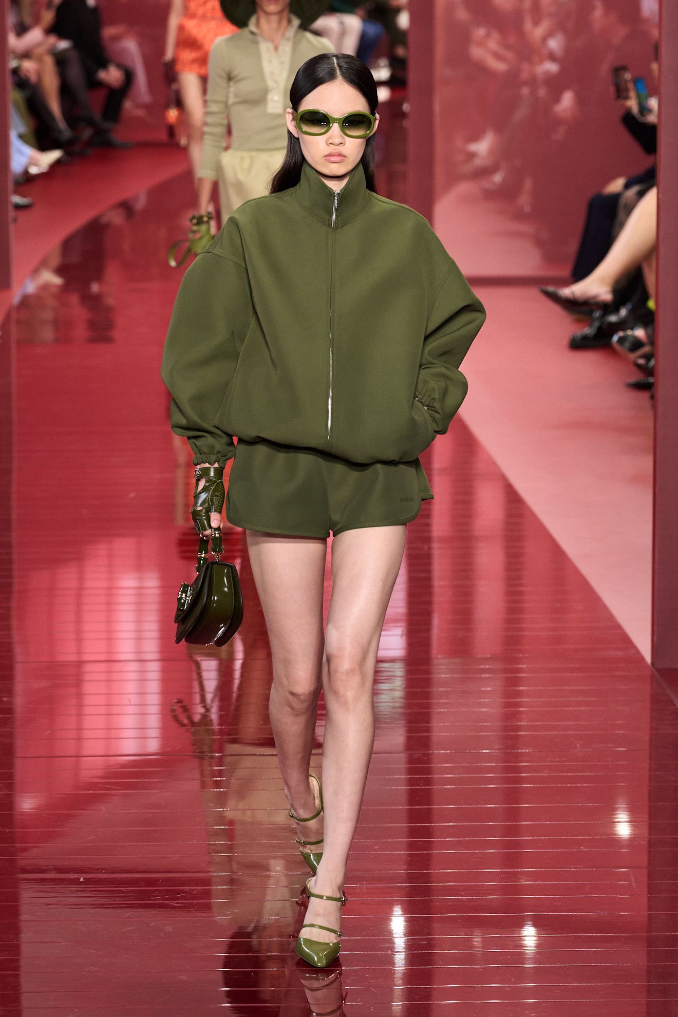 Woman in zip-up jacket and shorts.