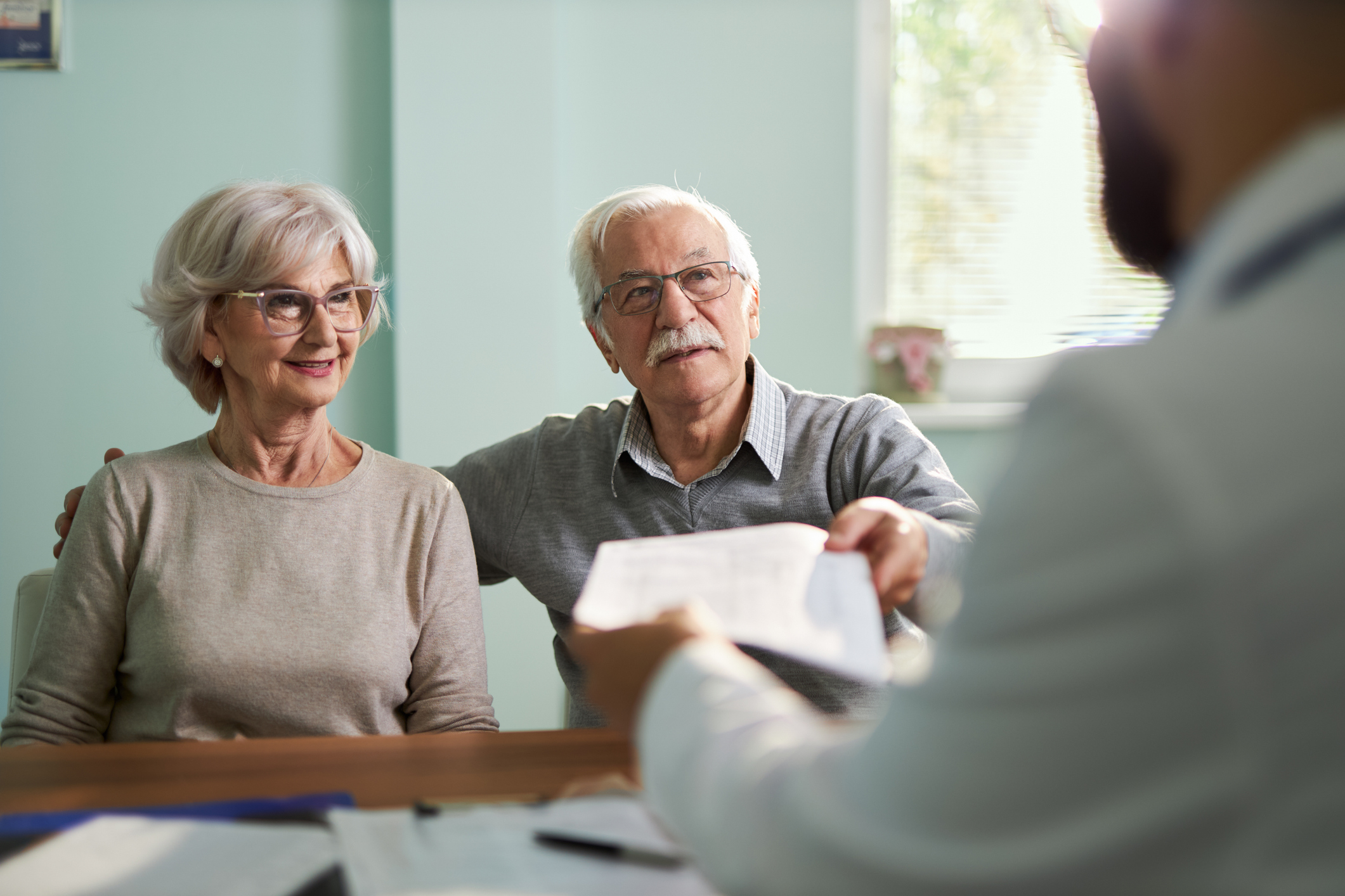 Older couple being handed a check