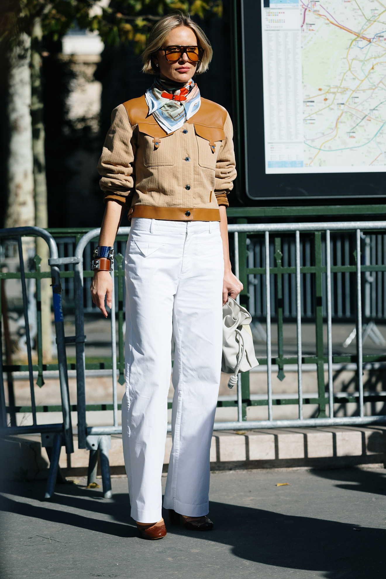 fashion week attendee wearing scarf, sunglasses, white jeans