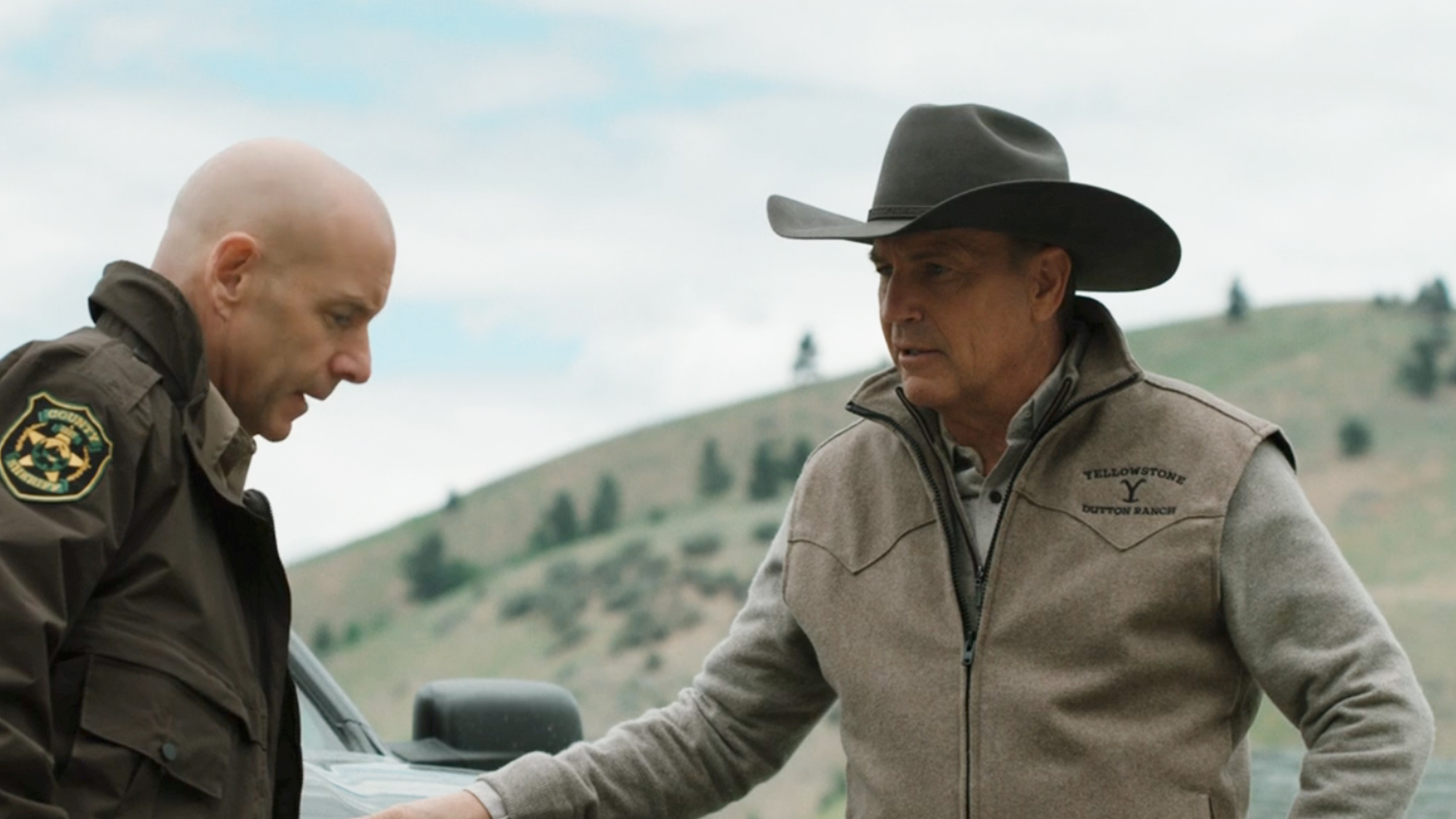 Kevin Costner speaking to a police officer in Yellowstone