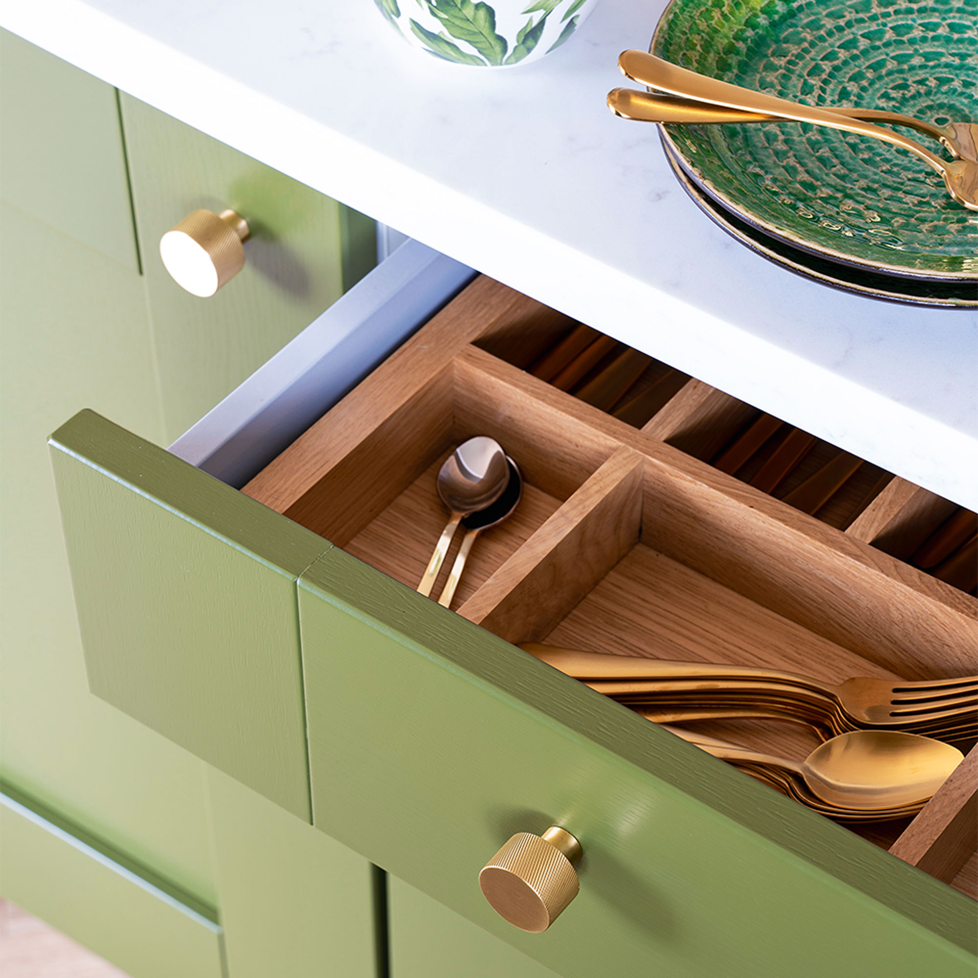 Green kitchen with wooden cutlery drawer