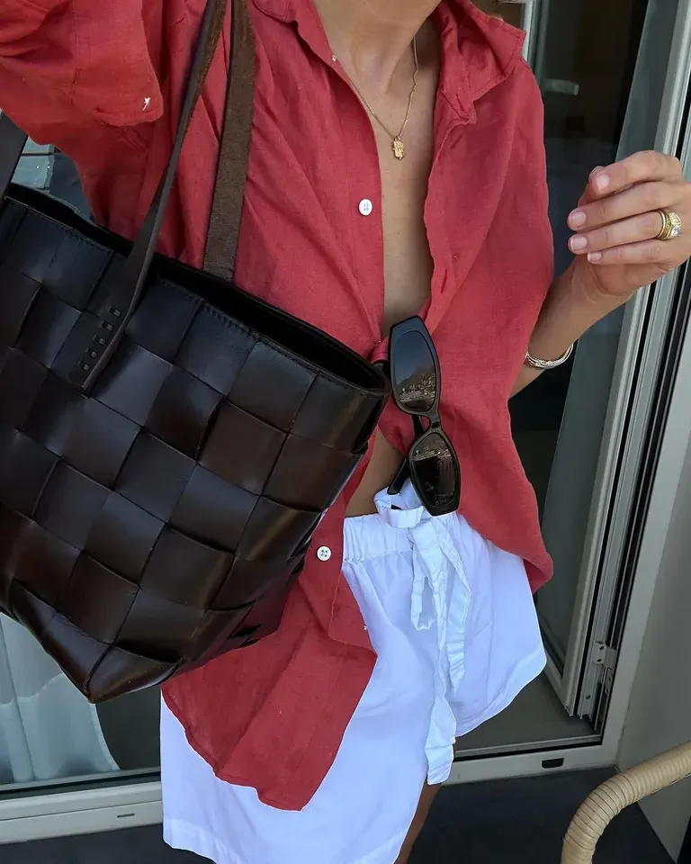 Woman in white drawstring shorts and red button-down
