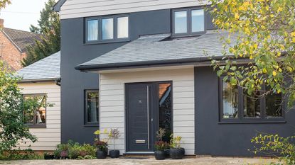 Exterior of a modern detached house with grey cladding and a paved driveway