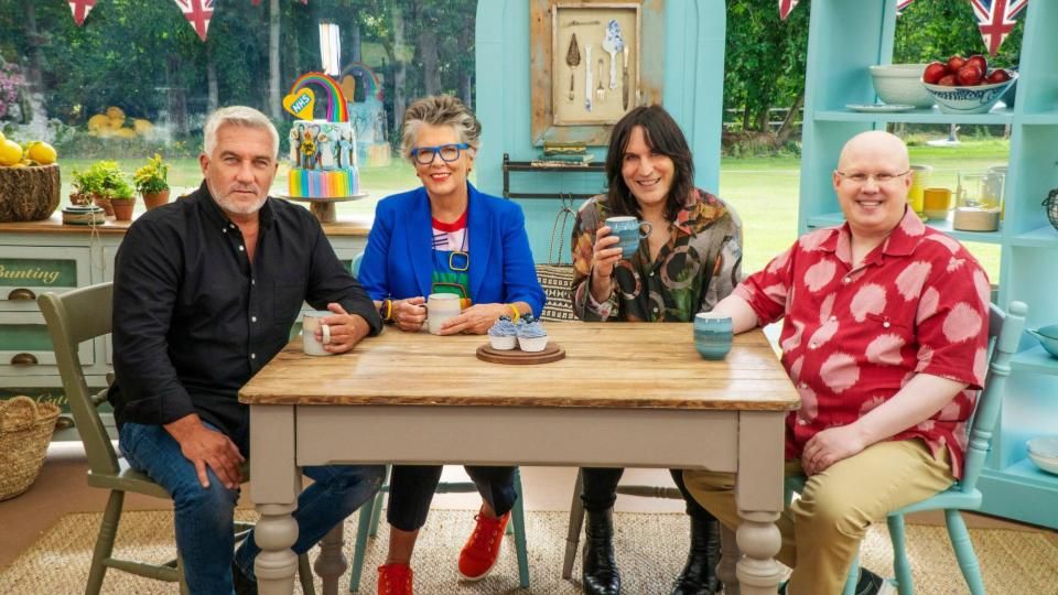 Paul Hollywood, Prue Leith, Noel Fielding, and Matt Lucas sit at a table with some cakes on it 