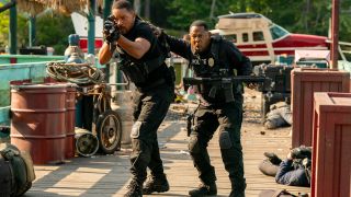 Will Smith takes aim while moving forward as Martin Lawrence supports him in Bad Boys: Ride or Die.