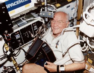 Astronaut John Glenn smiles while flying on NASA's STS-98 space shuttle mission in 1998.