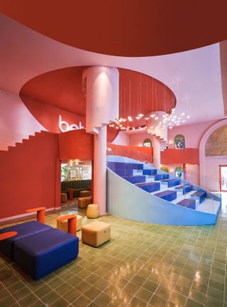 Colour and form take precedence over function at the Beta Cinema, Ho Chi Minh City, by Module K. Which has pink and blue walls, square chairs, gold floor tiles and bird shaped pendant lights.