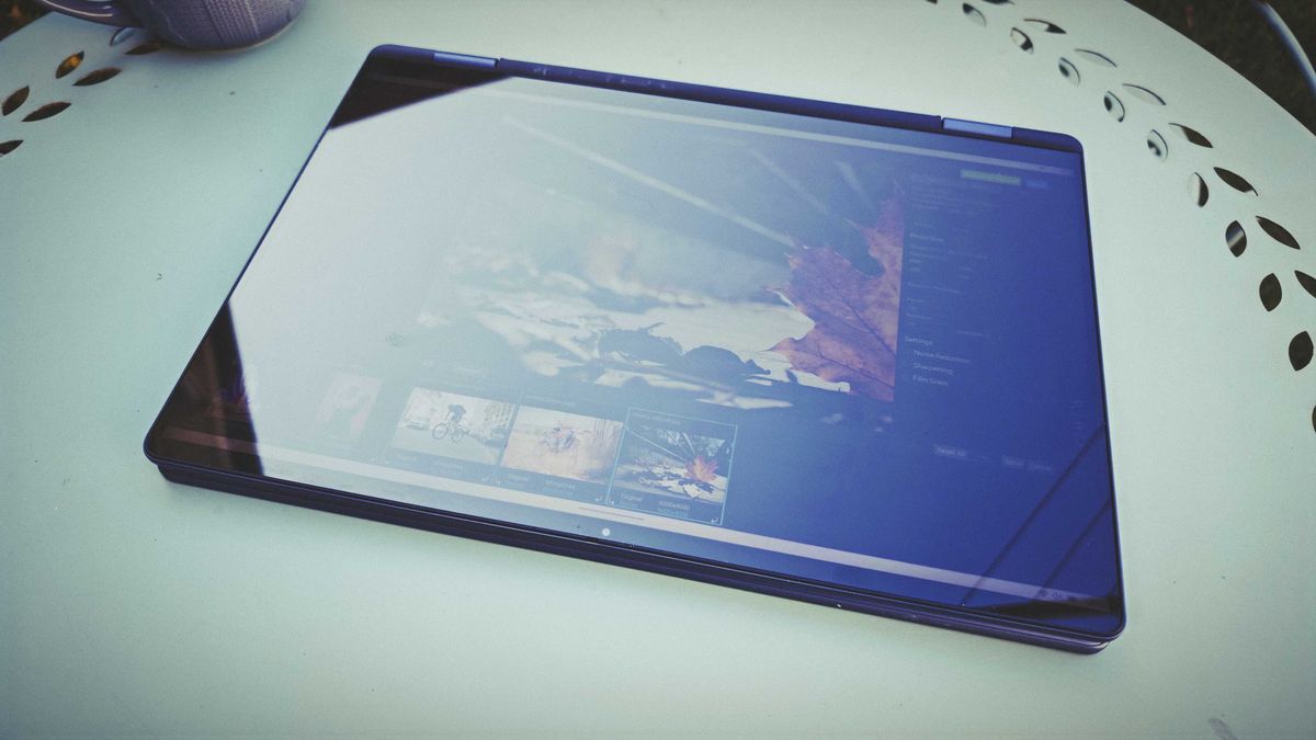 A Dell 16 Plus 2-in-1 laptop on a blue garden table