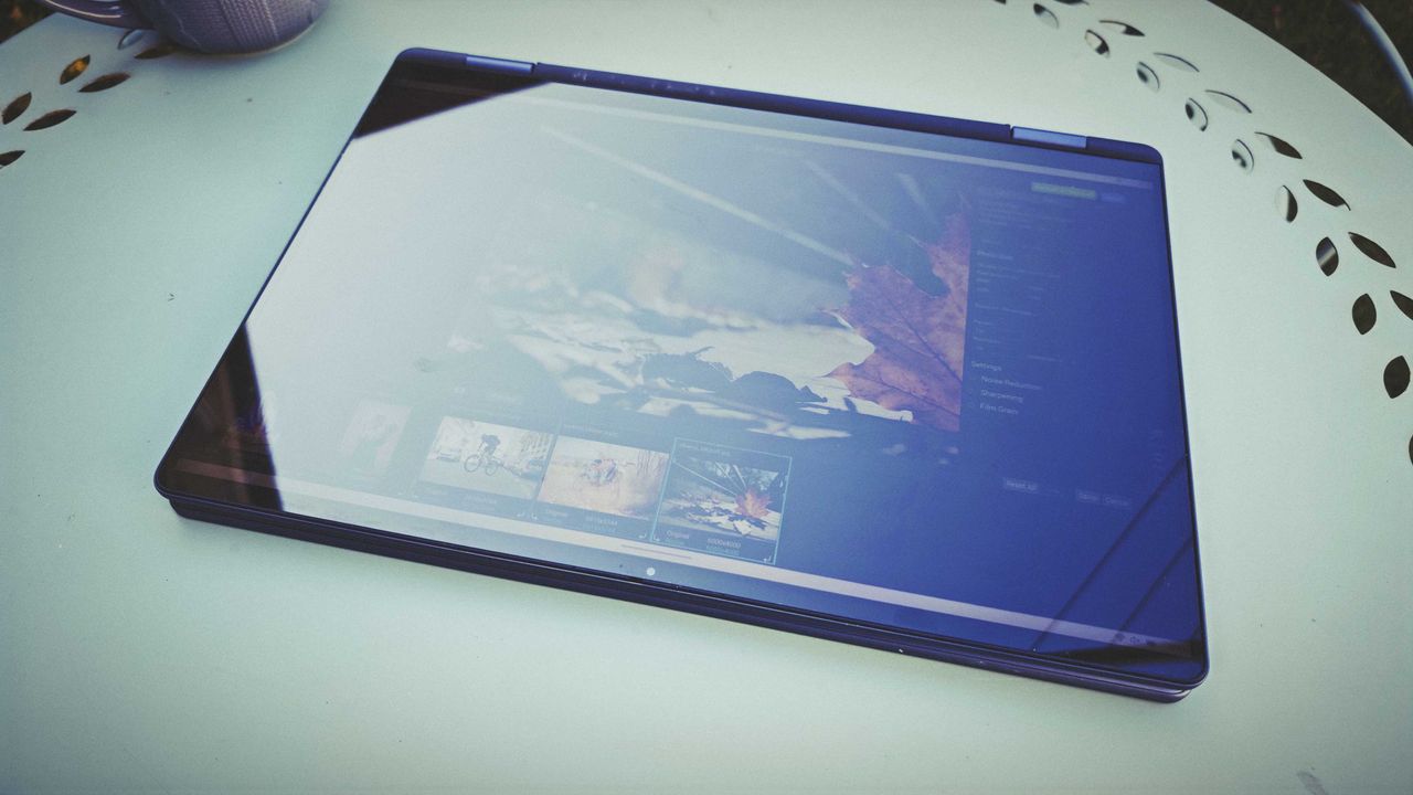 A Dell 16 Plus 2-in-1 laptop on a blue garden table