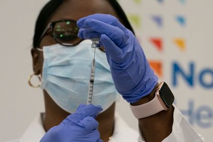 A doctor prepares to give a coronavirus vaccine.