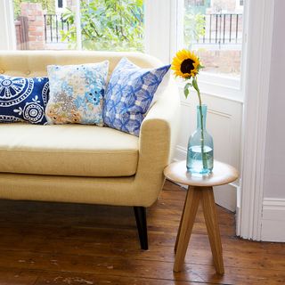 living room with wooden flooring and wooden stool with glass vase and yellow flower