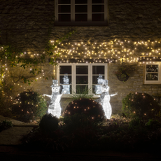 Christmas snowmen decorations outside a cottage window